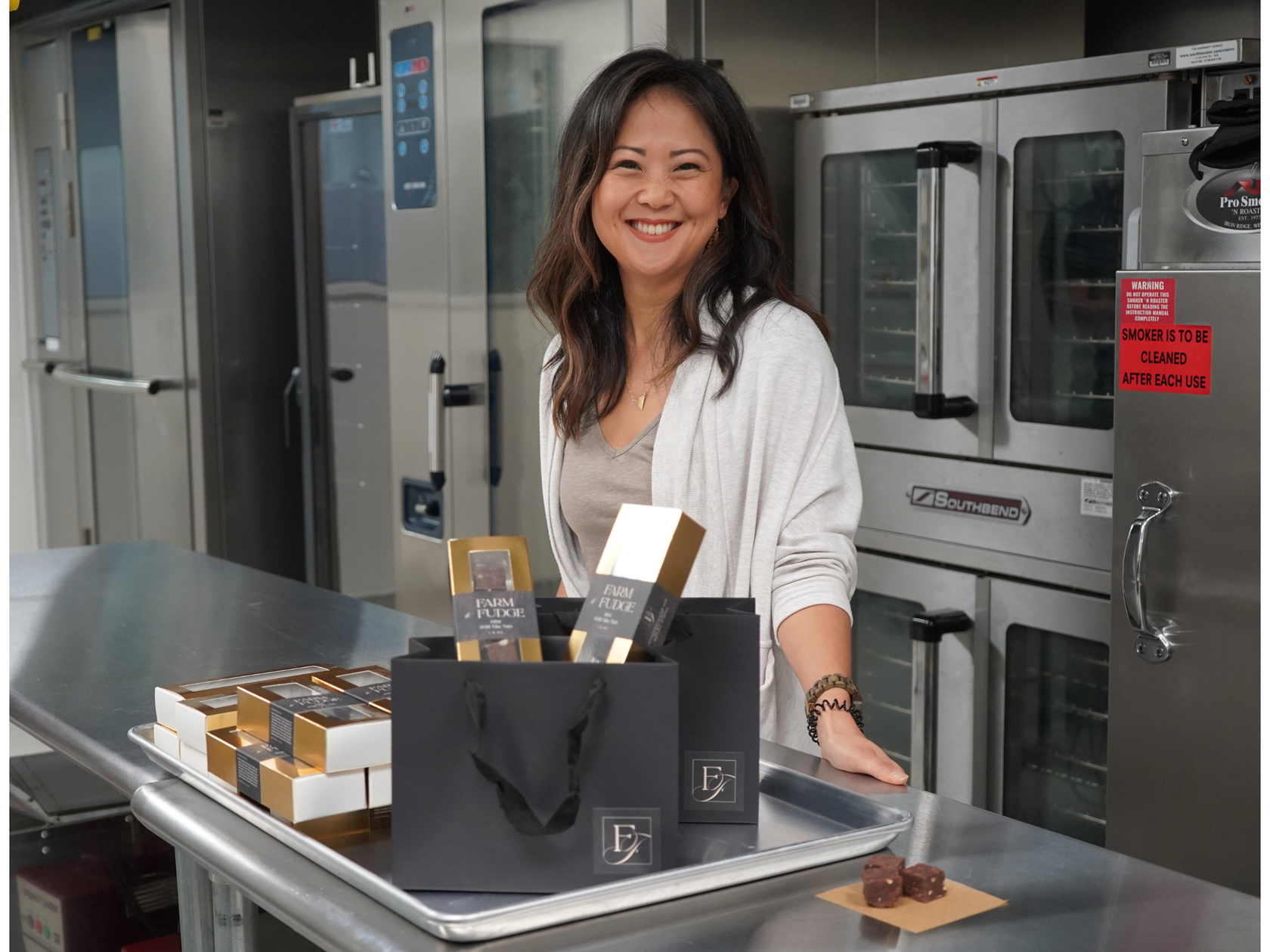Woman standing behind a counter with branded products in a kitchen setting
