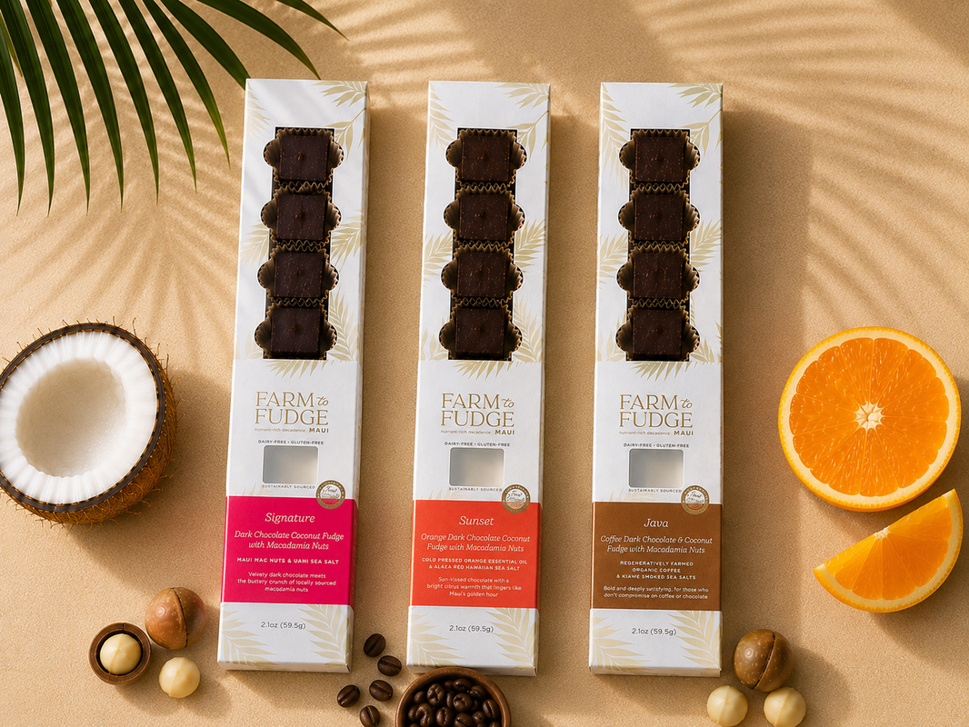 image Three boxes of Farm to Fudge fudge on a beige surface with coconut, orange, and coffee beans.